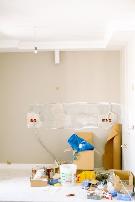 Inside a residential property during a home relocation process, the image depicts a laptop on a desk displaying lines of programming code, suggesting preparation for moving or logistical planning. The